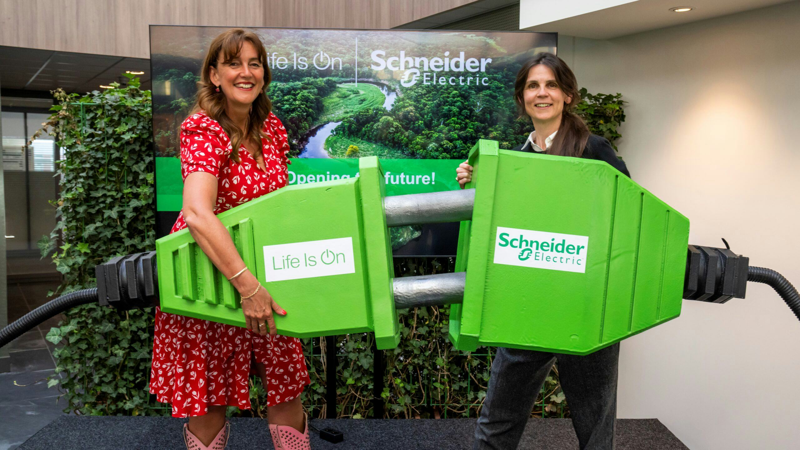 Wethouder Marja Ruigrok (L) van de gemeente Haarlemmermeer en Debby Slofstra (R), country president van Schneider Electric Nederland openen het vernieuwde kantoor