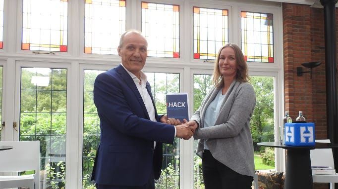 Henny de Haas overhandigde tijdens een seminar over cybercriminaliteit het eerste boek-exemplaar aan Petra Oldengarm, directeur van Cyberveilig Nederland.