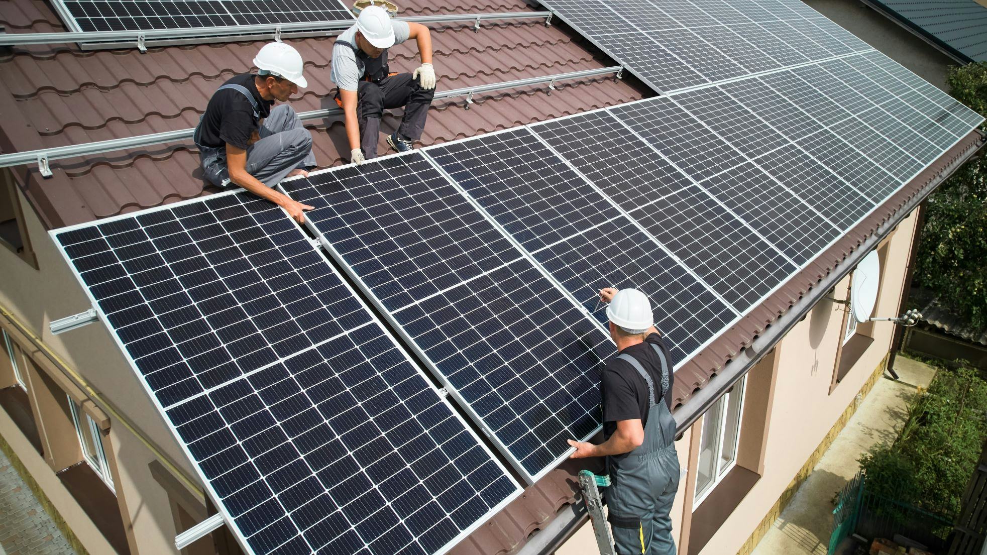 Een voorbeeld van hoe het niet moet. De installateurs zitten niet vast, staan op een ladder te werken en er is geen dakrandbeveiliging.