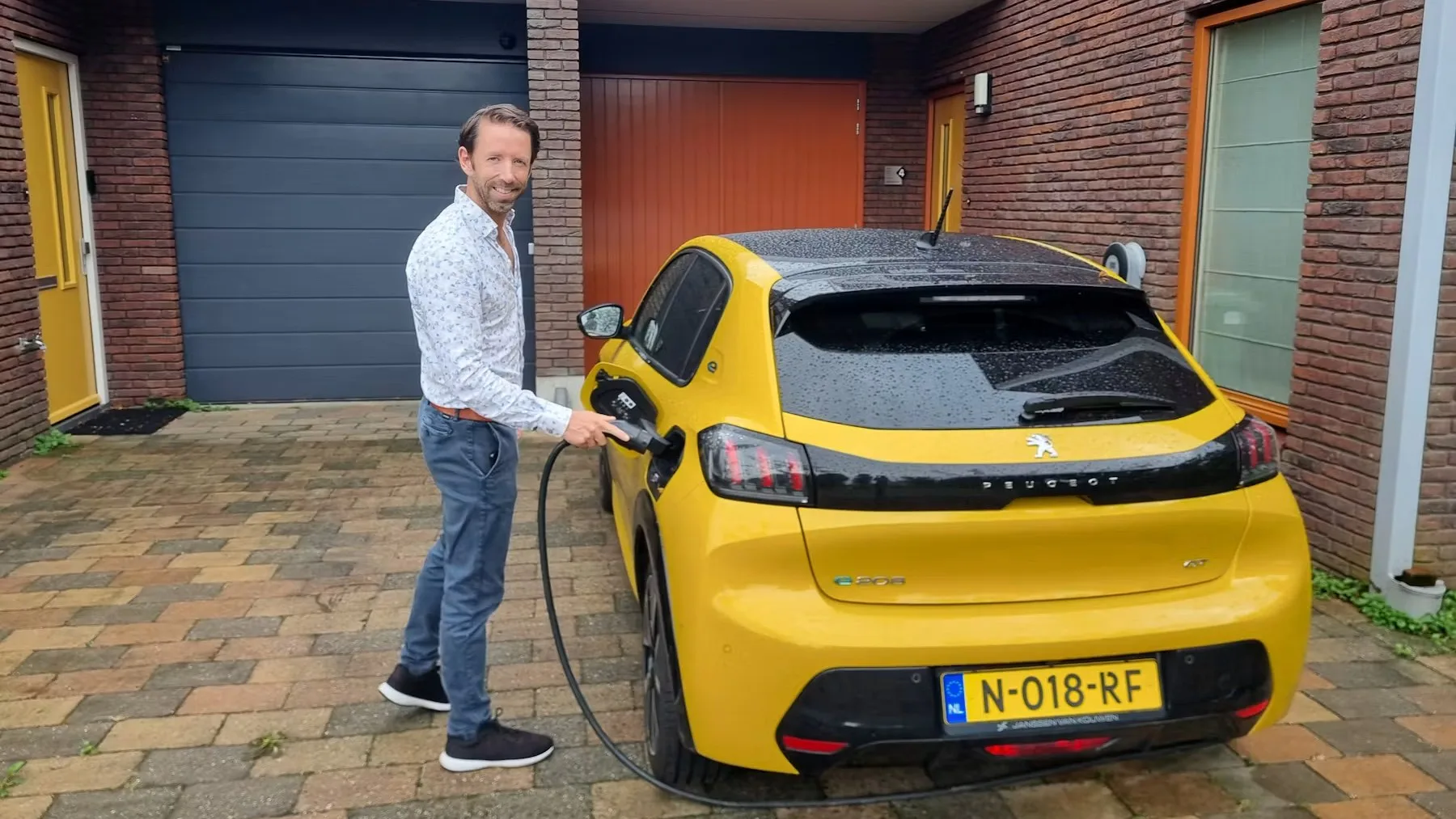 Sam van Gentevoort, mede-oprichter van Voltbee, bij een elektrische auto.